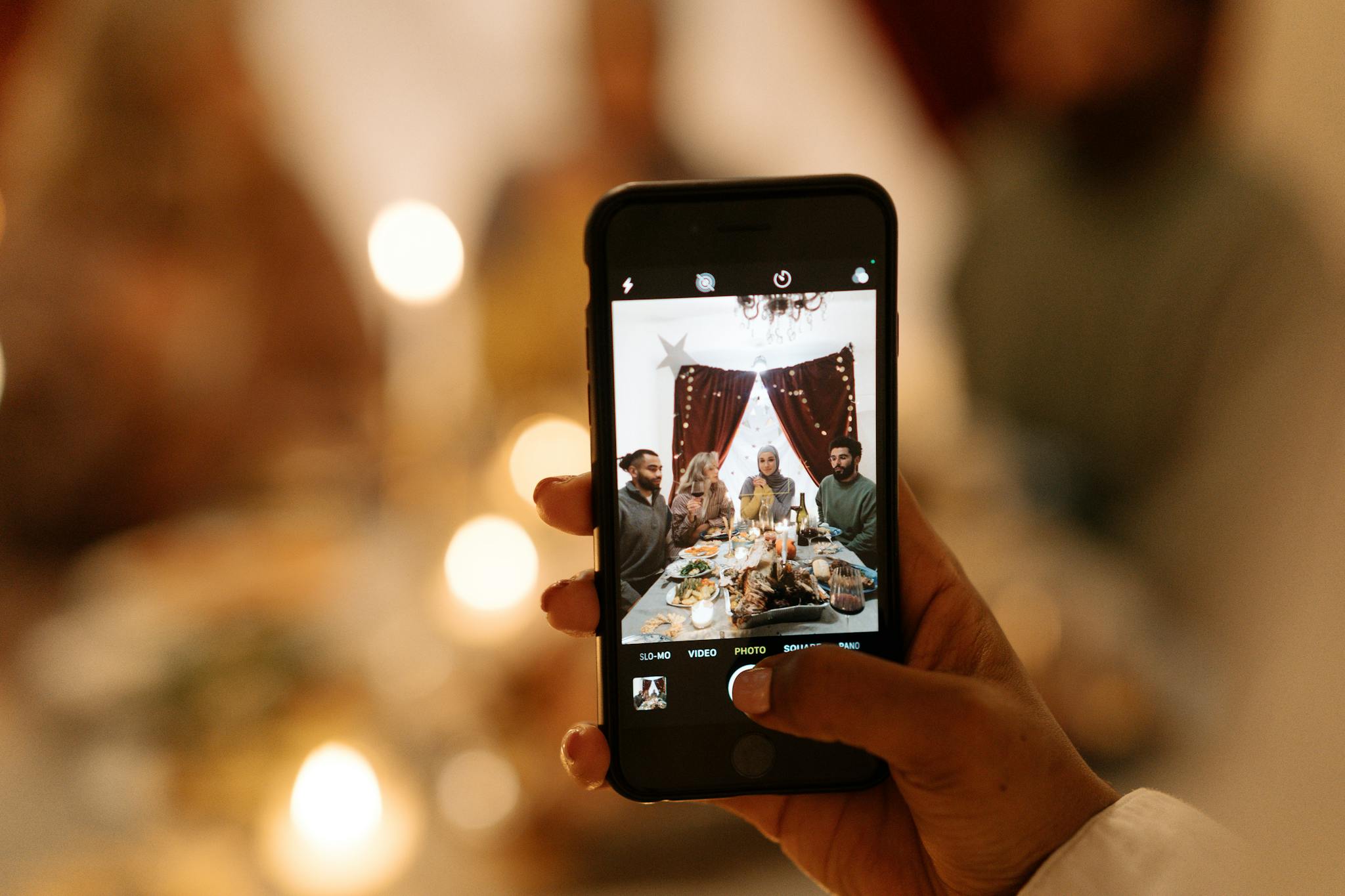 A family gathers for a holiday dinner, captured creatively through a smartphone lens.