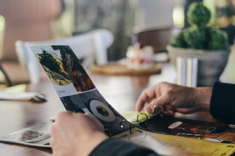 A person looking through a restaurant menu indoors, showcasing food selection.