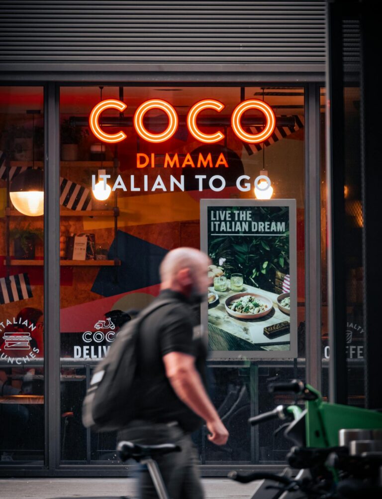 Street view of Coco Di Mama Italian restaurant with a passerby in London.